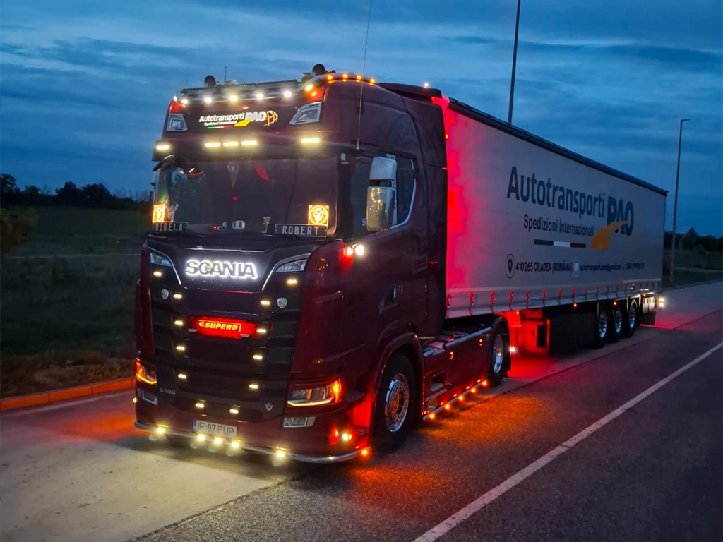 camion Scania fotografiat in noapte cu luminile aprinse