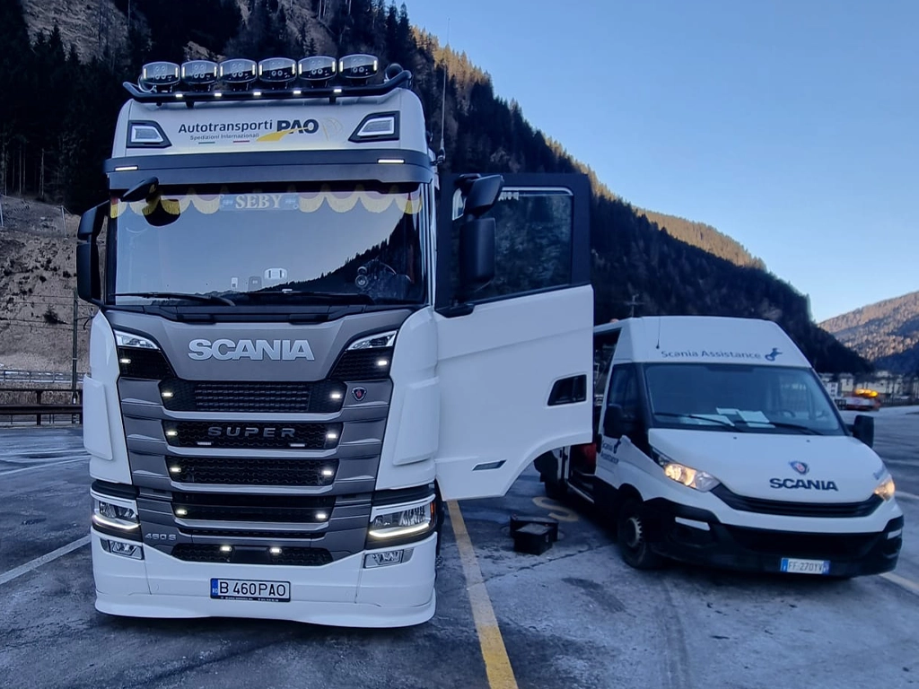 camion Scania in parcare cu o masina de service langa el