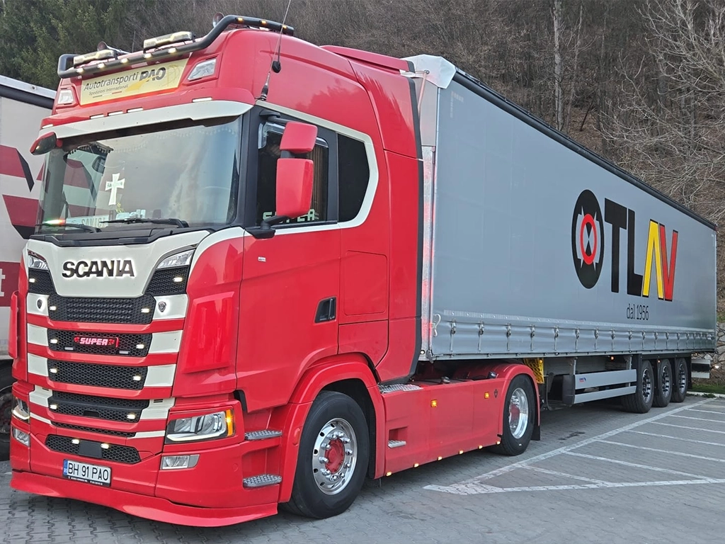 Ansamblu camion Scania rosu si semiremorca cu prelata pregatit pentru transport de marfuri international